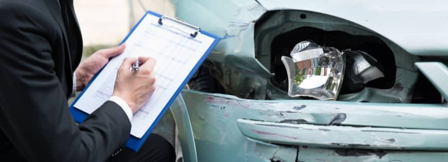 Perito pasando inspecci�n a un coche accidentado