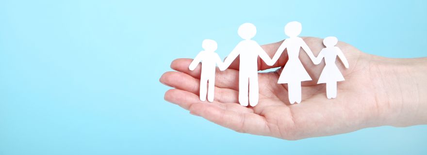 Familia hecha de papel sobre mano de mujer