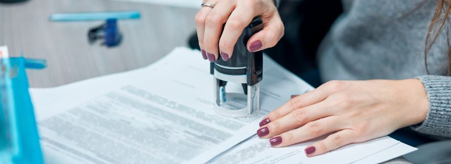 Manos femeninas sellan documento en el registro de seguros de vida