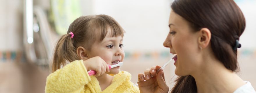 Seguro dental familiar: niña aprende a cepillarse