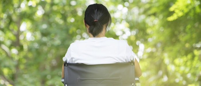 Mujer de espaldas sentada en una silla de ruedas
