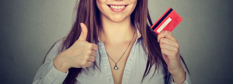 Mujer sujeta su tarjeta de crédito gratis